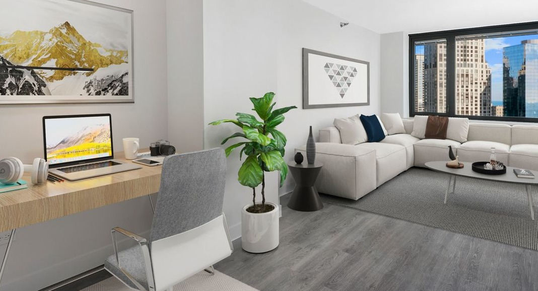 Inviting living area with a comfortable couch and a dedicated workspace, featuring city views at Cityfront Place