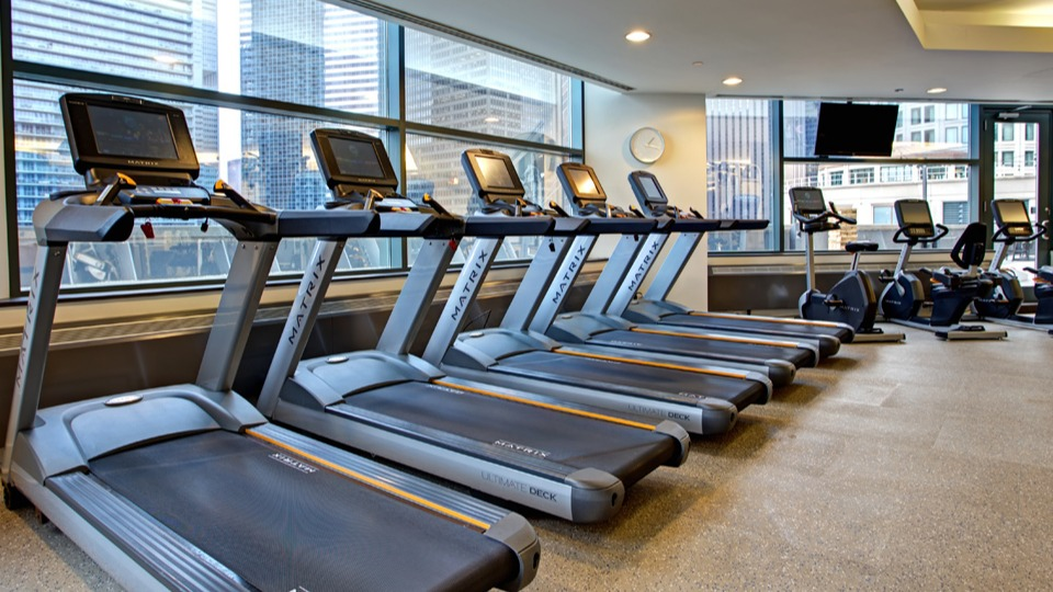 Fitness center at Cityfront Place with a row of modern treadmills, ellipticals, and city views