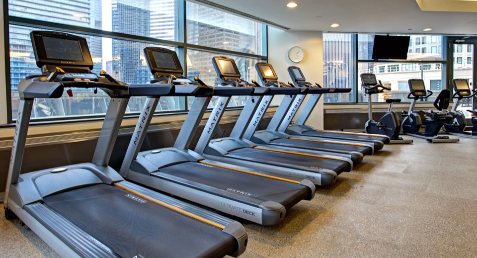 Fitness center at Cityfront Place with a row of modern treadmills, ellipticals, and city views