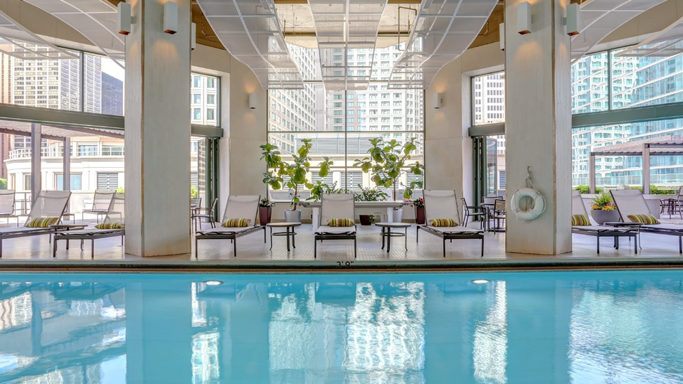 Inviting indoor swimming pool area at Cityfront Place, featuring lounge chairs and ample natural light