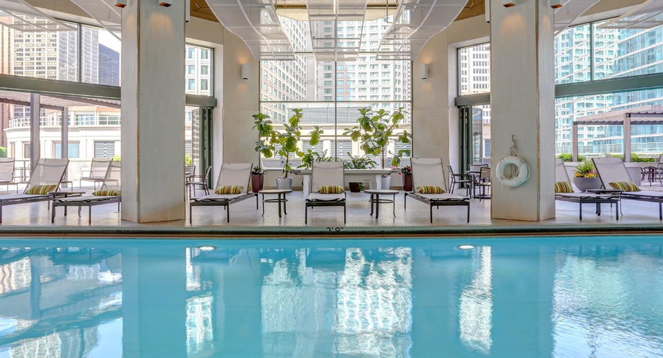 Inviting indoor swimming pool area at Cityfront Place, featuring lounge chairs and ample natural light