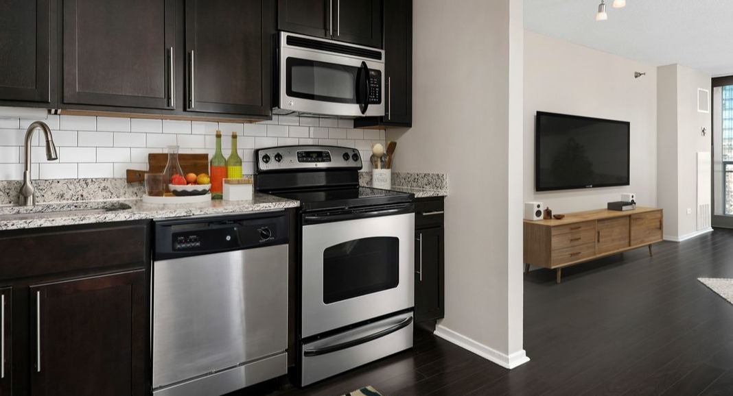 Modern kitchen at Cityfront Place featuring dark wood cabinets, stainless steel appliances, and an open concept layout