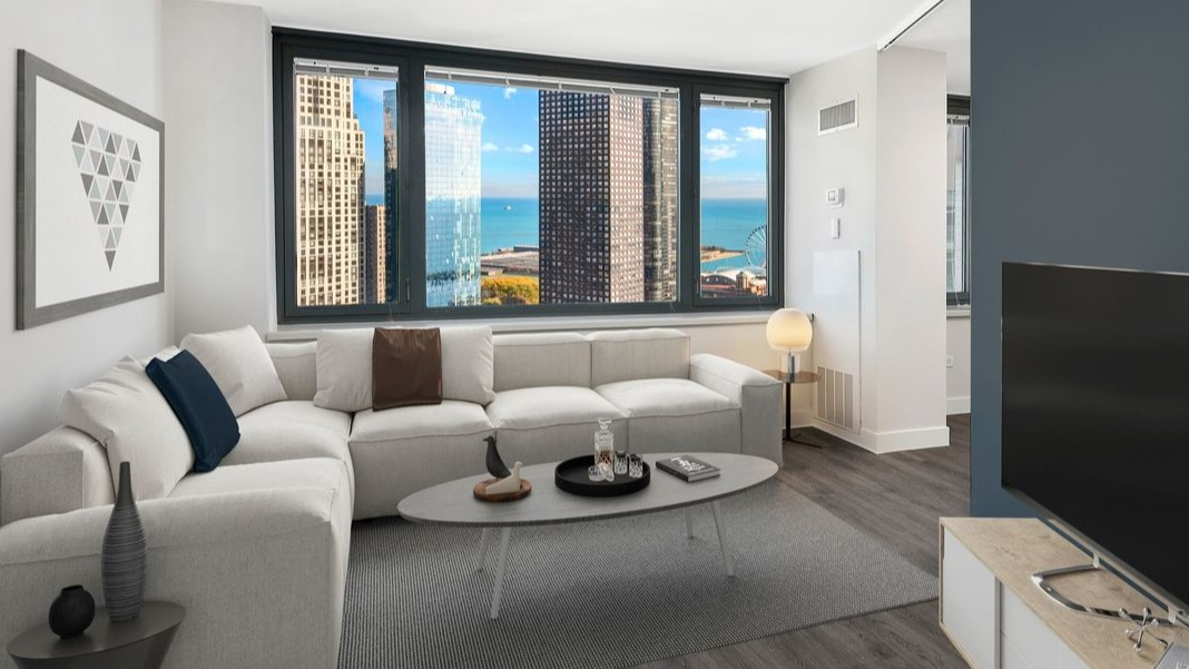 Spacious living room at Cityfront Place with a plush sectional, contemporary decor, and stunning views of Lake Michigan
