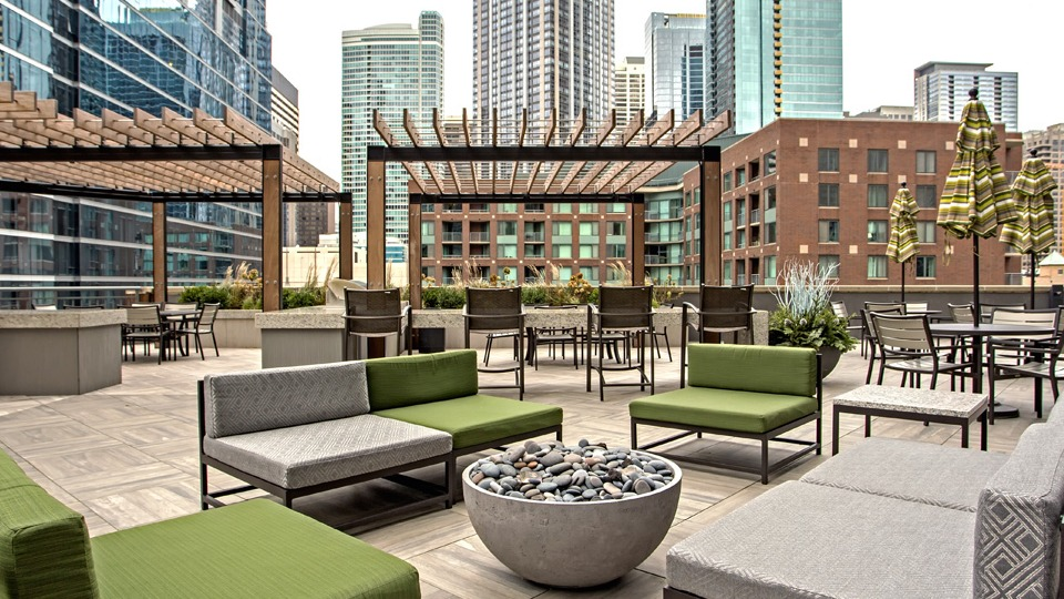 Stylish rooftop lounge at Cityfront Place with modern outdoor seating, pergolas, and a cozy fire pit