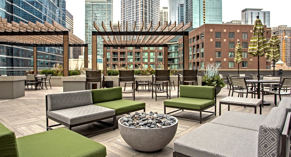 Stylish rooftop lounge at Cityfront Place with modern outdoor seating, pergolas, and a cozy fire pit