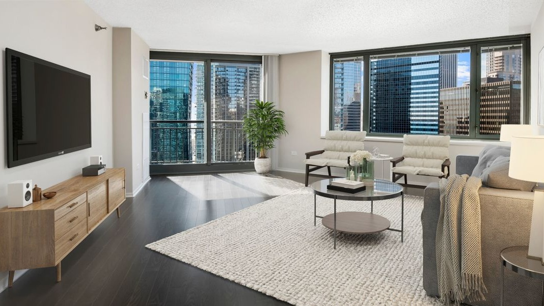 Expansive living room at Cityfront Place with a large rug, media console, and direct access to a private balcony