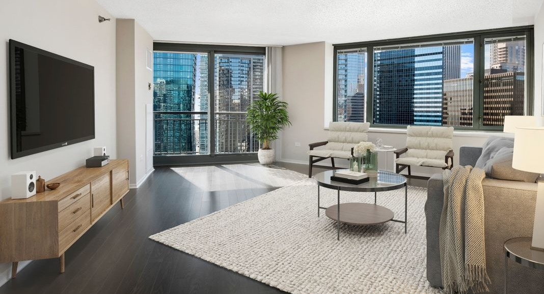 Expansive living room at Cityfront Place with a large rug, media console, and direct access to a private balcony