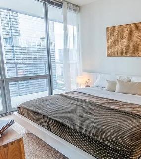 Modern bedroom with city views at Coast at Lakeshore East apartments in Chicago