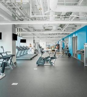 Spacious cardio gym at Coast at Lakeshore East apartments in Chicago. Modern equipment and plenty of room to exercise