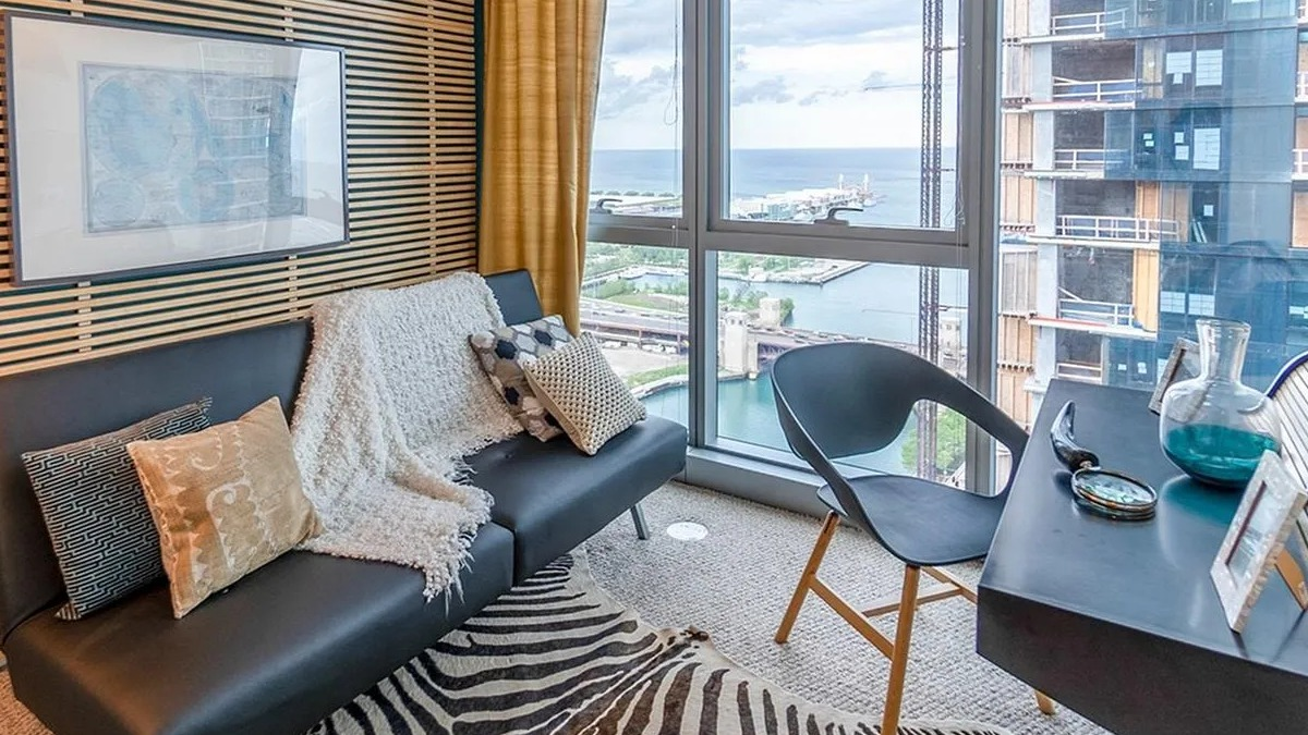 A cozy den or home office at Coast at Lakeshore East with unique wall paneling, a desk, and a fantastic lake view