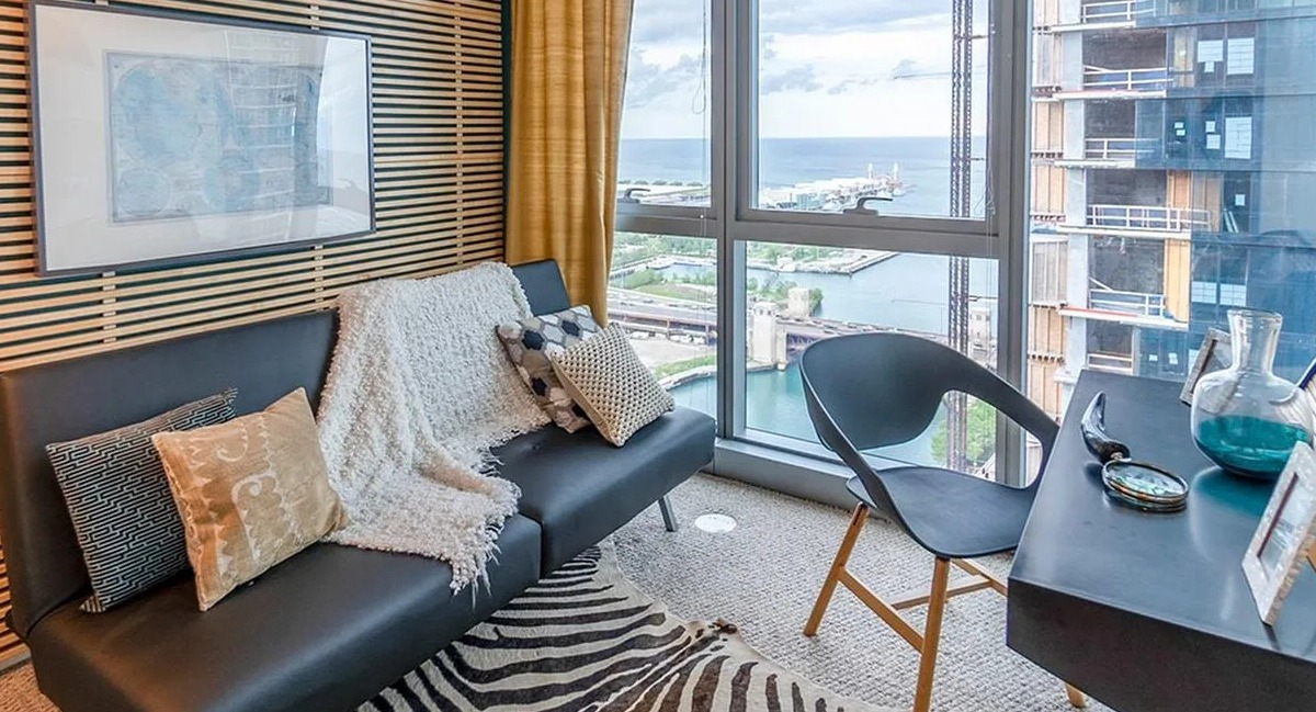 A cozy den or home office at Coast at Lakeshore East with unique wall paneling, a desk, and a fantastic lake view