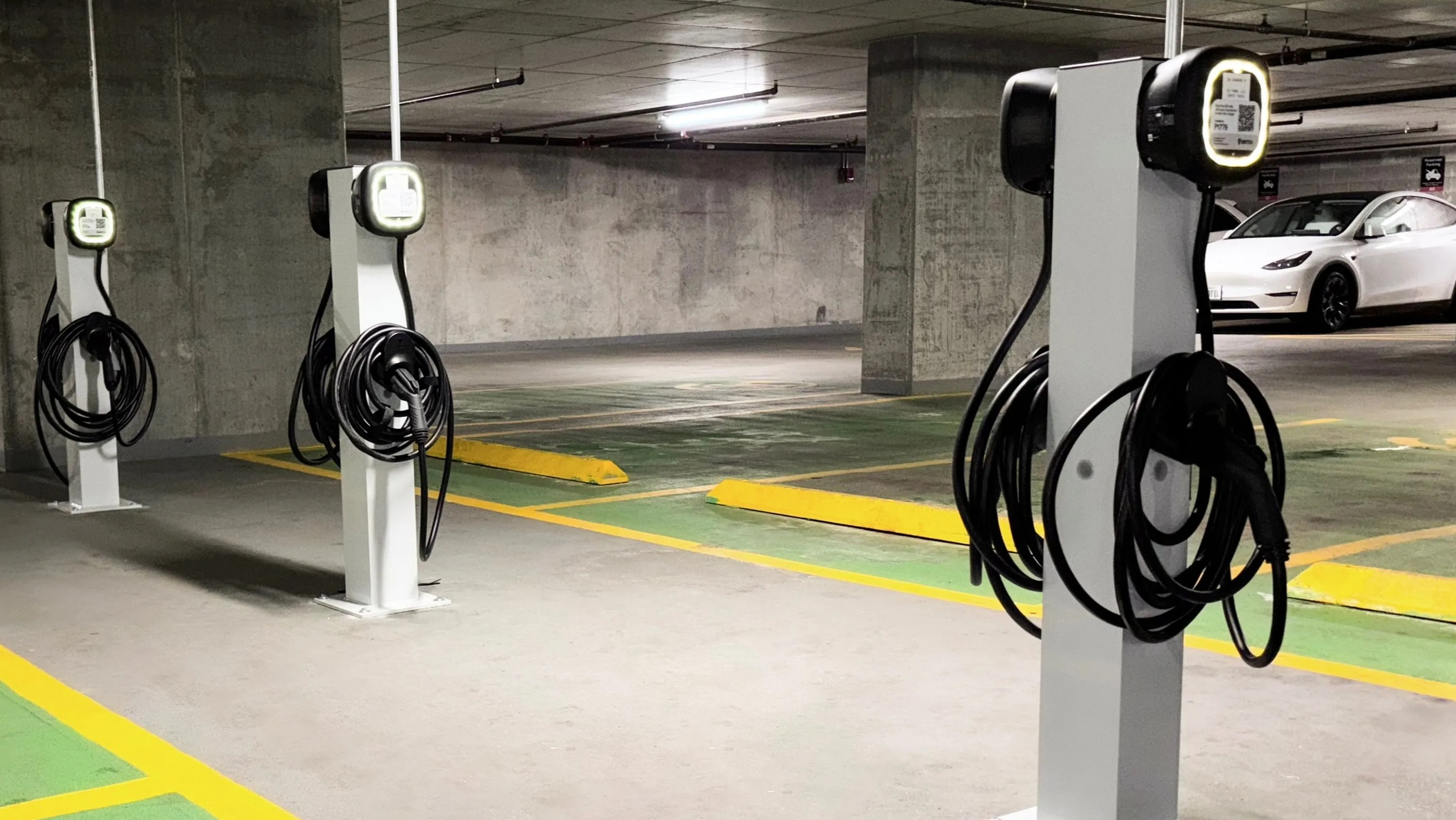 A well-lit underground parking garage at Coast at Lakeshore East, featuring multiple electric vehicle charging stations
