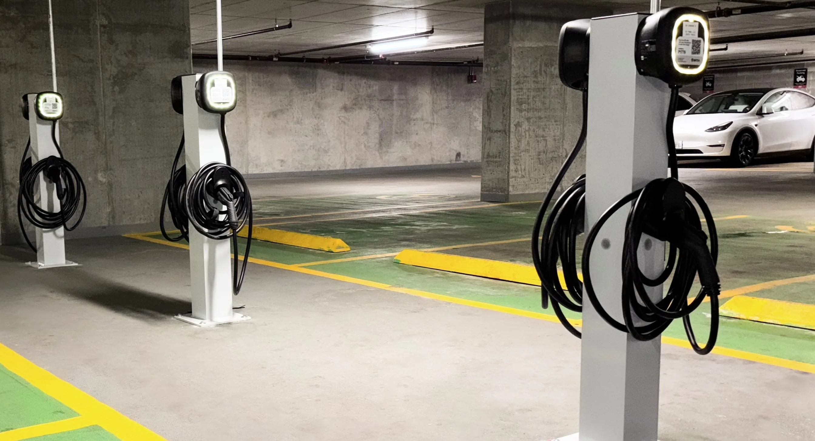 A well-lit underground parking garage at Coast at Lakeshore East, featuring multiple electric vehicle charging stations