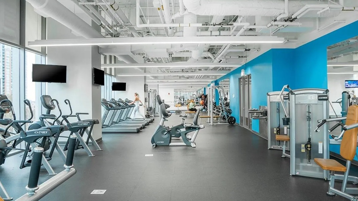 A bright and expansive fitness center at Coast at Lakeshore East with various cardio machines and weight equipment