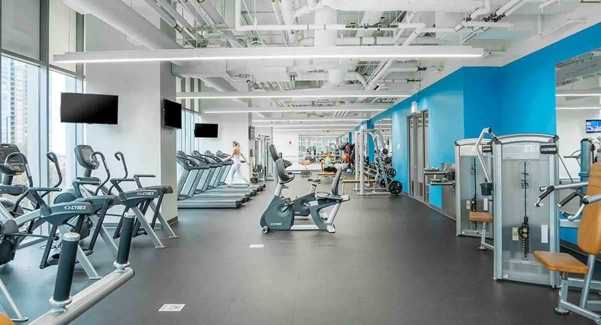 A bright and expansive fitness center at Coast at Lakeshore East with various cardio machines and weight equipment