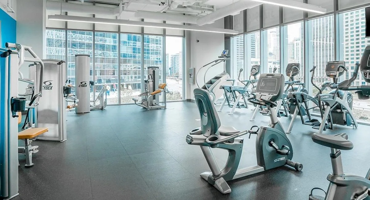 A modern gym at Coast at Lakeshore East, offering a wide array of fitness equipment and abundant natural light