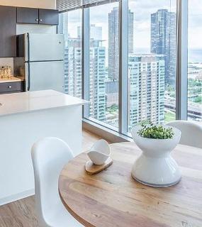 Modern kitchen and dining area with city views at Coast at Lakeshore East apartments in Chicago