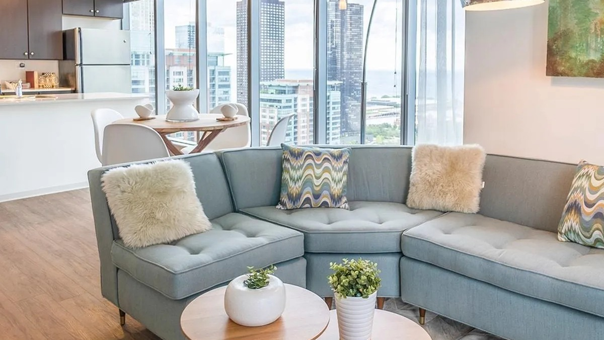 A bright living area at Coast at Lakeshore East with a comfortable sectional sofa and views of the city skyline