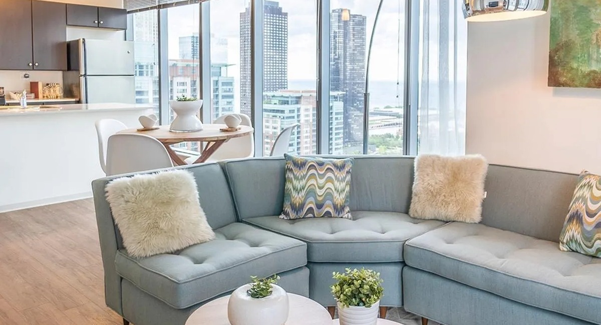 A bright living area at Coast at Lakeshore East with a comfortable sectional sofa and views of the city skyline