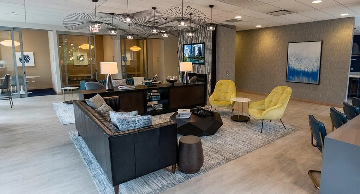A spacious and cozy lounge area at Coast at Lakeshore East with stylish lighting, comfortable seating, and a collaborative desk