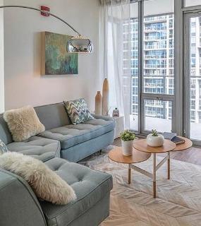 Another view of the modern living room with city views at Coast at Lakeshore East apartments in Chicago