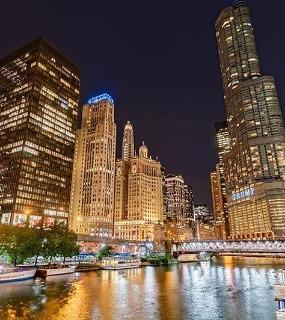 Night view of Chicago skyline and river lights from Coast at Lakeshore East apartments. Illuminated buildings and waterfront