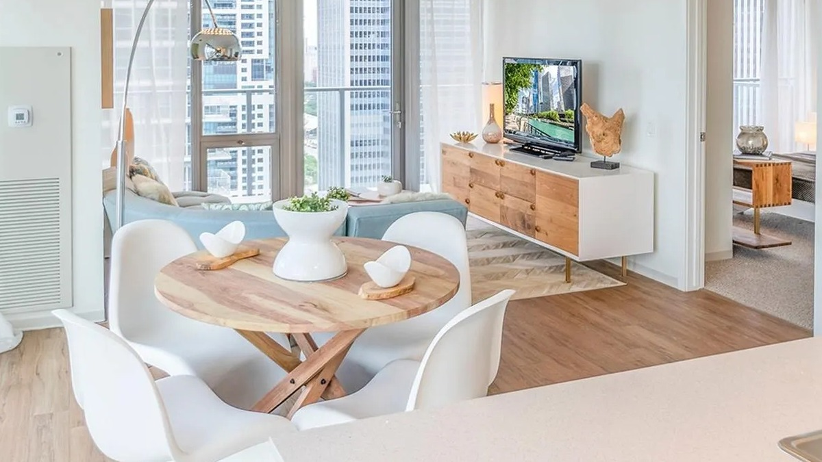 An open-concept living and dining area at Coast at Lakeshore East, with a round dining table and city views