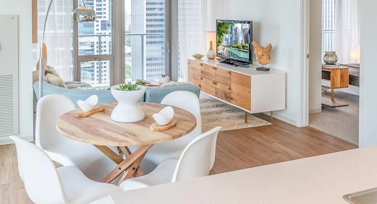 An open-concept living and dining area at Coast at Lakeshore East, with a round dining table and city views
