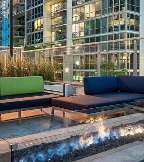 Outdoor lounge with a fire pit at Coast at Lakeshore East apartments in Chicago. Relaxing and social space