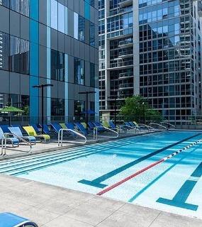 Outdoor swimming pool with lounge chairs at Coast at Lakeshore East apartments in Chicago