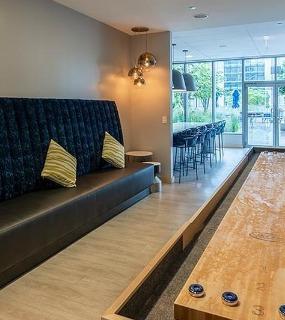 Resident lounge with shuffleboard and comfortable seating at Coast at Lakeshore East apartments in Chicago
