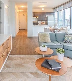 Modern living room with floor-to-ceiling windows and city views at Coast at Lakeshore East apartments