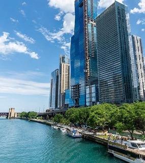 View of the Chicago Riverwalk with towering skyscrapers near Coast at Lakeshore East apartments