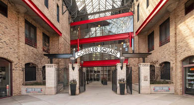 Grand entrance to Cobbler Square Lofts, featuring a historic arched gateway and stylish signage in Chicago