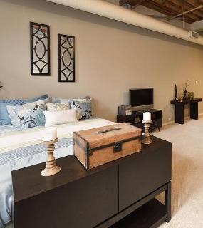 Cozy bedroom with modern furniture, warm lighting, and a stylish design at Cobbler Square Lofts in Chicago