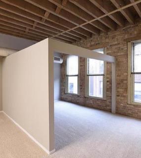 Elegant bedroom with a cozy ambiance, modern bed frame, and soft lighting at Cobbler Square Lofts in Chicago