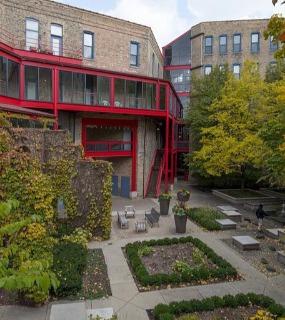Beautiful outdoor garden area with lush greenery and seating at Cobbler Square Lofts in Chicago