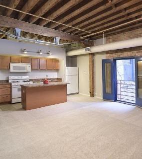 Open-concept kitchen and living space with modern finishes at Cobbler Square Lofts in Chicago