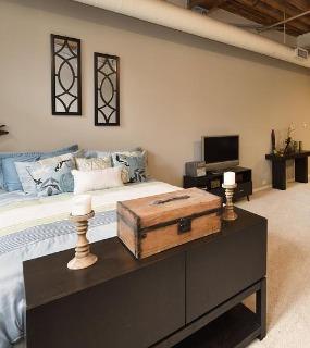 Modern bedroom suite with stylish furniture, soft bedding, and a cozy atmosphere at Cobbler Square Lofts in Chicago