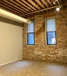 Modern living room featuring comfortable seating, elegant décor, and ample natural light at Cobbler Square Lofts in Chicago