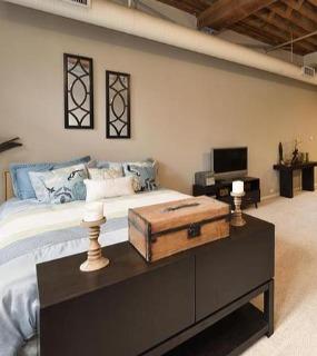 Stylish bedroom featuring contemporary furniture, elegant décor, and ample natural light at Cobbler Square Lofts in Chicago