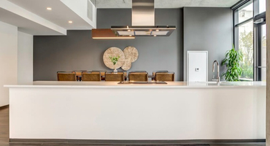 A large, modern community kitchen and lounge area with a spacious island and contemporary design at Coeval Apartments in Chicago