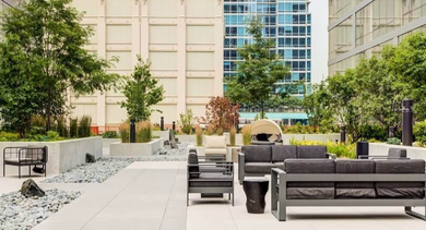 Serene outdoor courtyard with various seating arrangements, green landscaping, and modern design at Coeval Apartments in Chicago