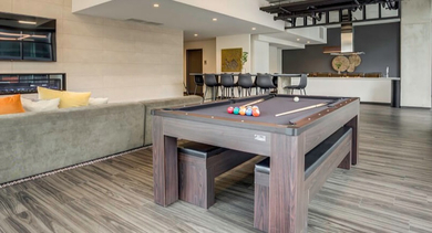 Vibrant game room and lounge area with a billiard table, comfortable seating, and a fireplace at Coeval Apartments in Chicago
