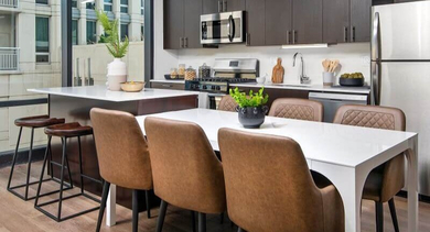 Modern kitchen with a large island, stainless steel appliances, and ample dining space at Coeval Apartments in Chicago