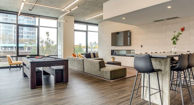 Contemporary resident lounge with a billiards table, comfortable seating, and a modern fireplace at Coeval Apartments in Chicago