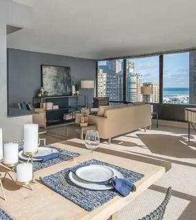 Open-concept dining and living space with modern furniture, lake views, and natural light at Columbus Plazs