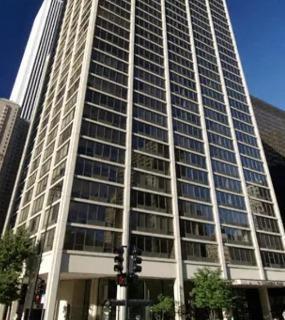 Tall modern high-rise building with glass windows and a clear blue sky at Columbus Plaza