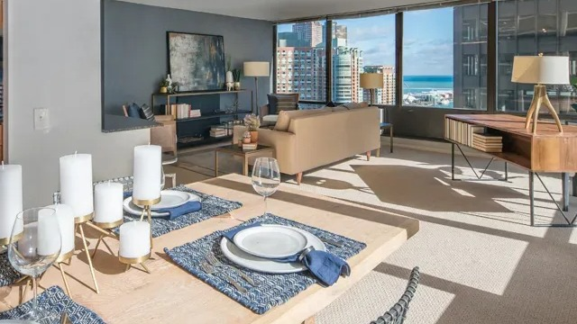 A spacious living and dining area with modern decor and a stunning view of Lake Michigan from Columbus Plaza