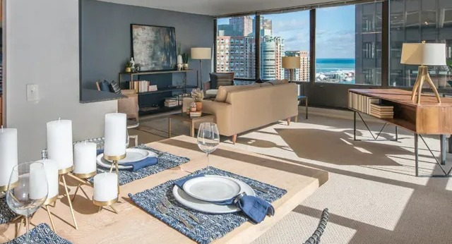 A spacious living and dining area with modern decor and a stunning view of Lake Michigan from Columbus Plaza